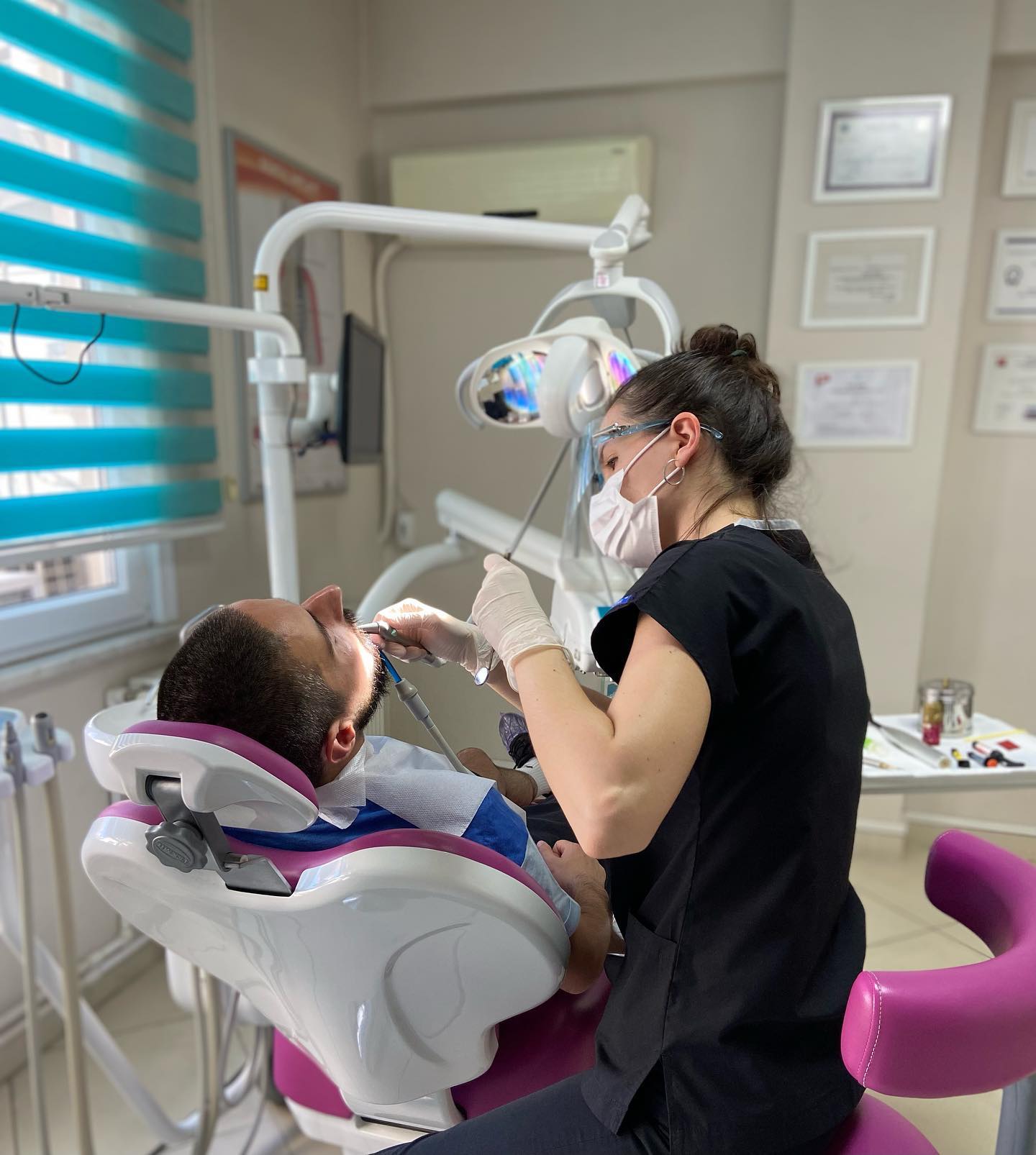 Elis Esen’in klinik koltuğundaki hastaya diş uygulaması